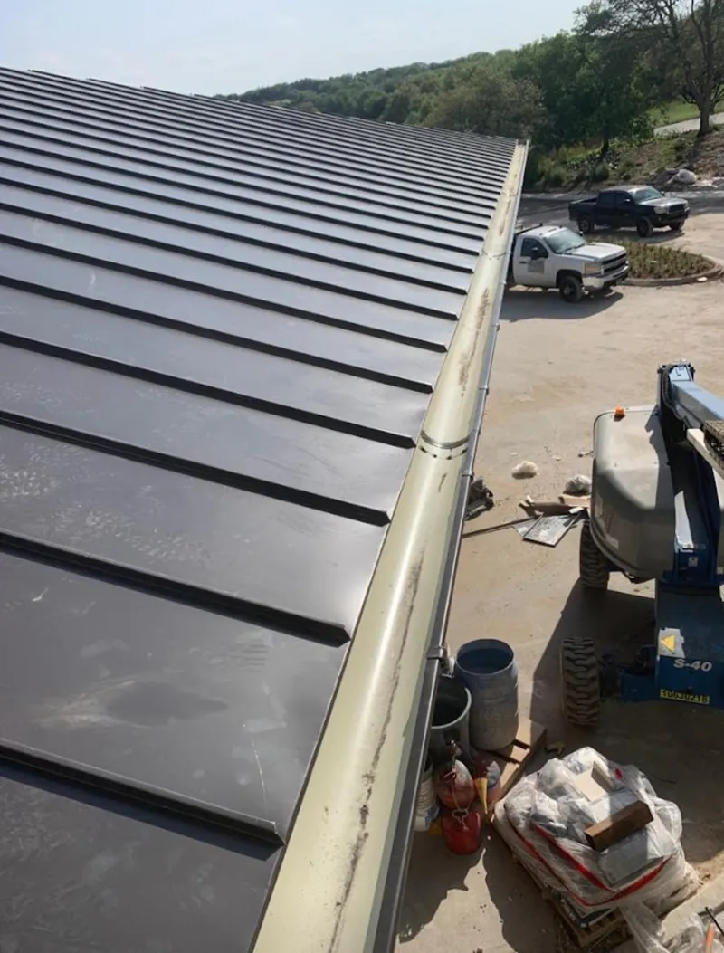 Standing seam panel and gutter detail on a metal roofing jobsite in Woodstock